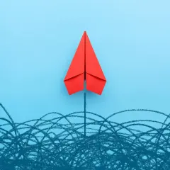 A red paper airplane soars above a chaotic scribble, symbolizing a new board of directors breaking through challenges.