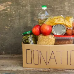 A donation box filled with food items like pasta, apples, pickles, and eggs, perfect for fundraising ideas for homeless shelters.