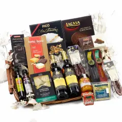 A gourmet gift basket overflowing with Spanish delicacies: wine, chocolates, turrones, olive oil, and cured meats, perfect for silent auction basket ideas.