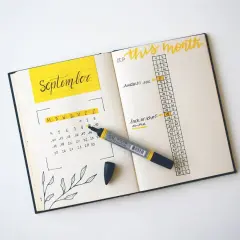 A September calendar and monthly agenda in a bullet journal, with a yellow marker.