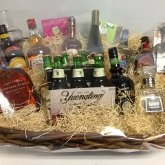 A festive basket filled with spirits and beer, perfect for unique charity gift basket ideas. Includes Woodford Reserve, Yuengling, and 1800 Tequila.