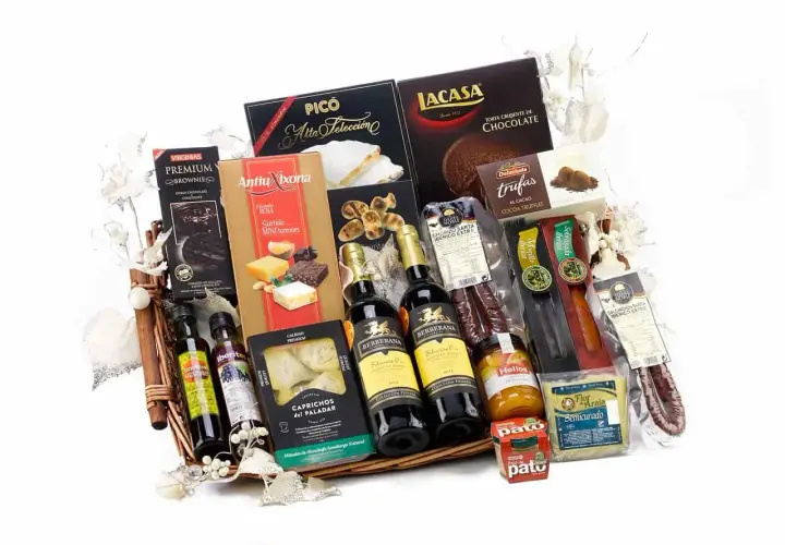 A gourmet gift basket overflowing with Spanish delicacies: wine, chocolates, turrones, olive oil, and cured meats, perfect for silent auction basket ideas.
