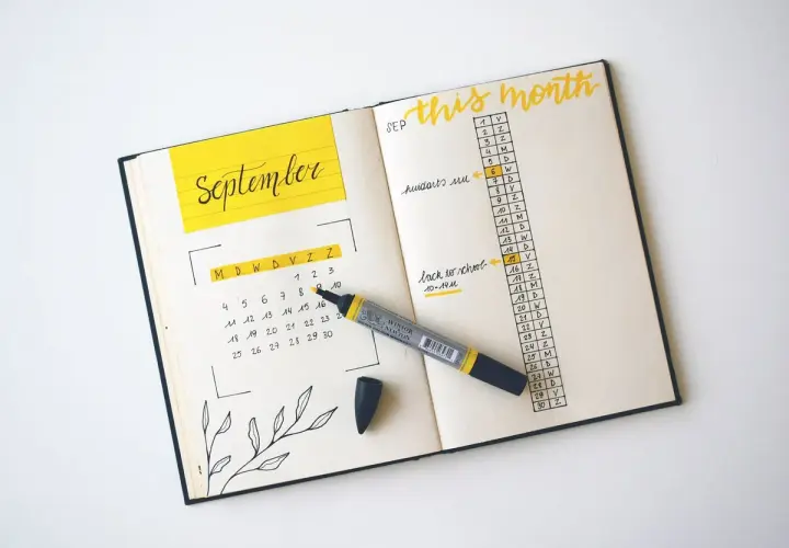 A September calendar and monthly agenda in a bullet journal, with a yellow marker.