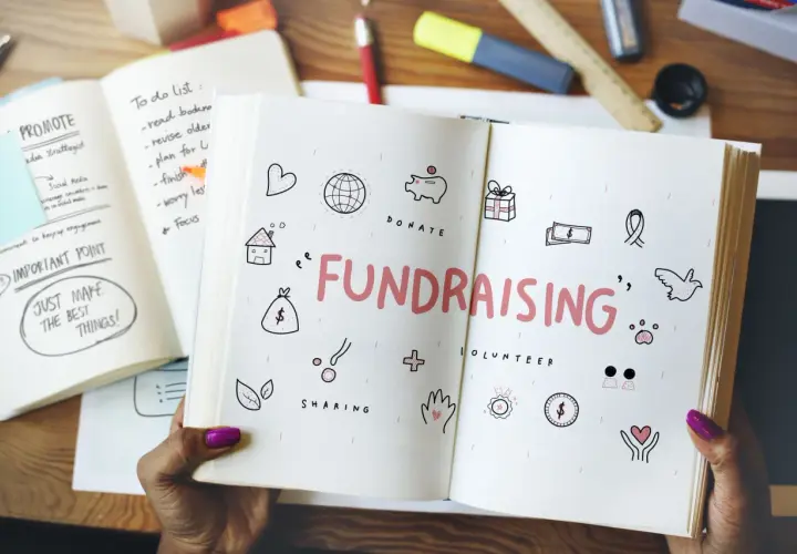 Open notebook with "FUNDRAISING" and icons for easy fundraisers. A to-do list and "Just Make the Best Things!" are visible.