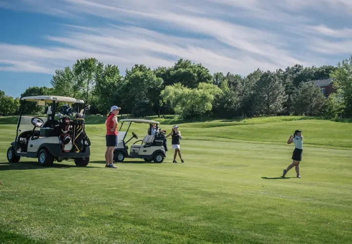 Women golfers on a sunny course, with carts and clubs ready. A charity golf tournament can last a full day, from morning to late afternoon.