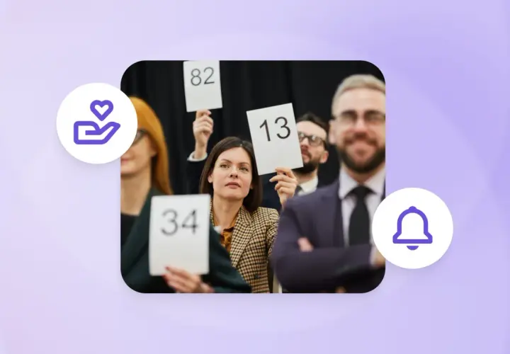 People at an auction, holding up bid numbers like 34, 82, and 13, participating in a paddle raise.