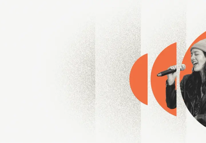 A woman sings into a microphone, her eyes closed in passion. Explore music volunteer opportunities and share your voice.