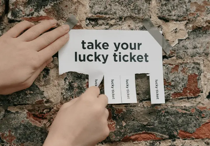 Hands tear off "lucky ticket" strips from a poster on a brick wall, offering great raffle ideas.