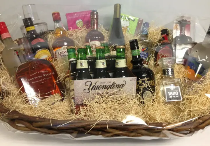 A festive basket filled with spirits and beer, perfect for unique charity gift basket ideas. Includes Woodford Reserve, Yuengling, and 1800 Tequila.