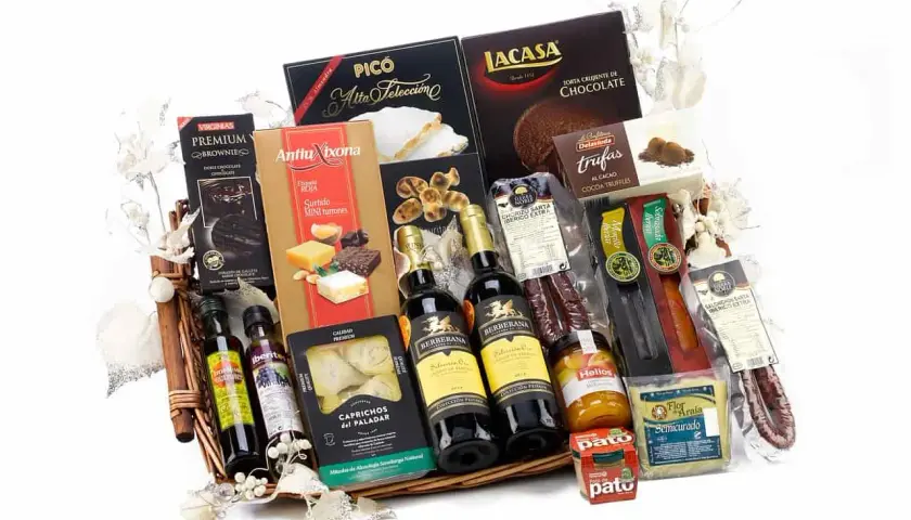 A gourmet gift basket overflowing with Spanish delicacies: wine, chocolates, turrones, olive oil, and cured meats, perfect for silent auction basket ideas.