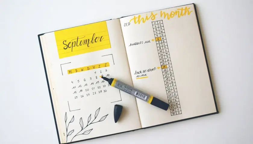 A September calendar and monthly agenda in a bullet journal, with a yellow marker.