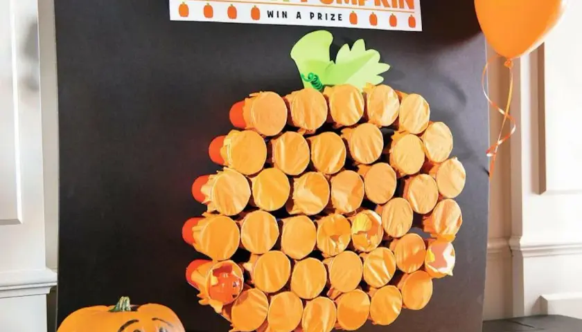 Poke-a-Pumpkin" game board, a fun fall festival idea for adults. Orange cups form a pumpkin shape, hiding prizes.