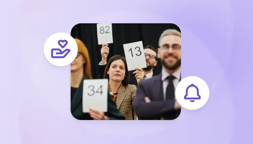 People at an auction, holding up bid numbers like 34, 82, and 13, participating in a paddle raise.