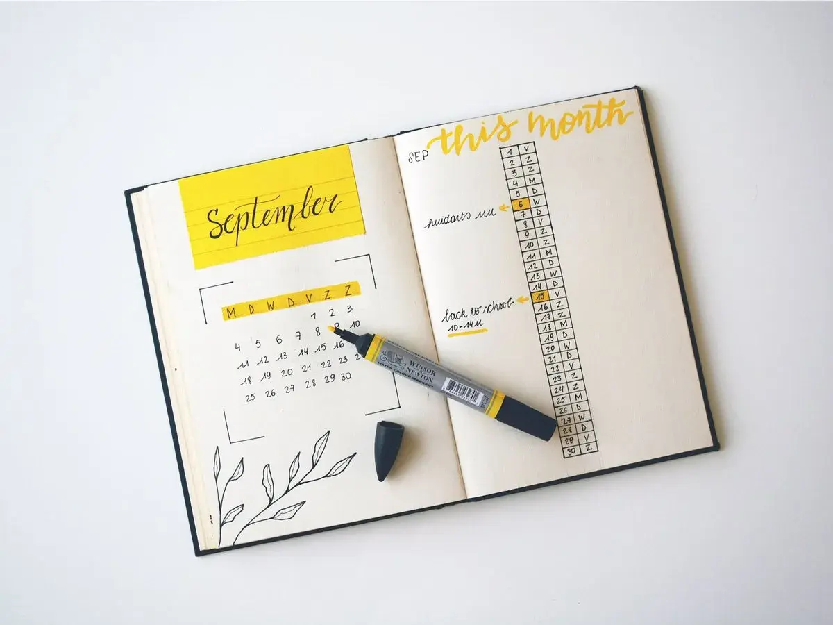 A September calendar and monthly agenda in a bullet journal, with a yellow marker.