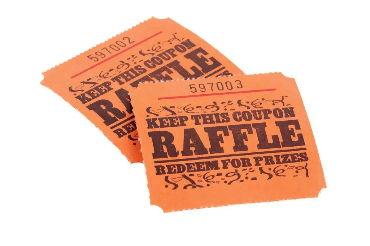 Two orange raffle tickets, numbered 597002 and 597003, with "RAFFLE" and "REDEEM FOR PRIZES" printed on them. These could be used for a fundraiser, but check Arizona raffle laws first.