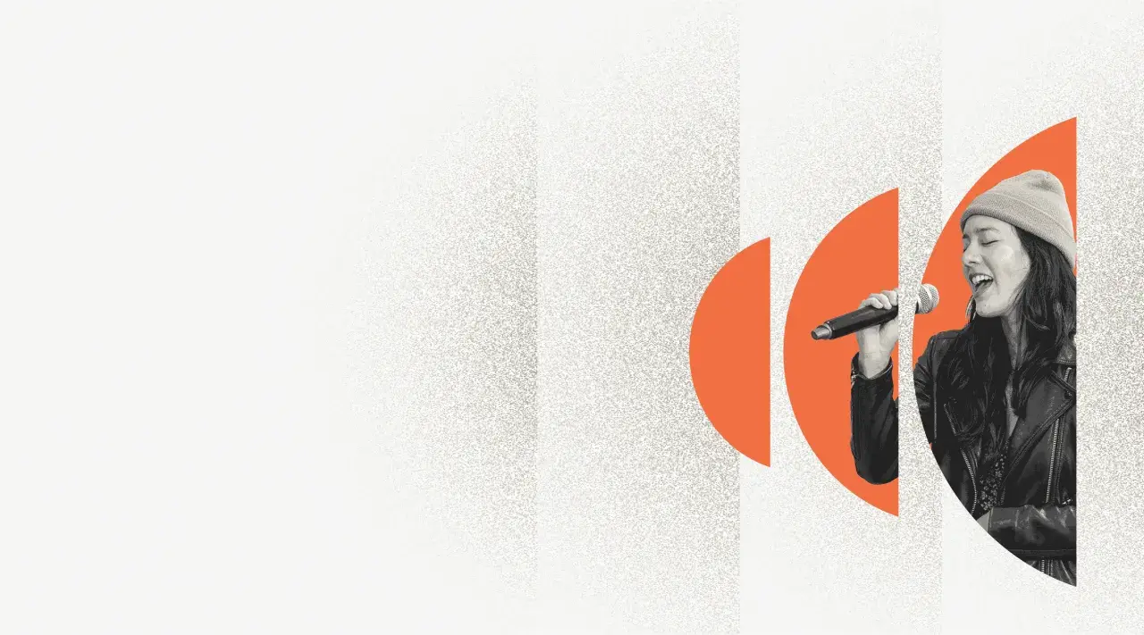 A woman sings into a microphone, her eyes closed in passion. Explore music volunteer opportunities and share your voice.