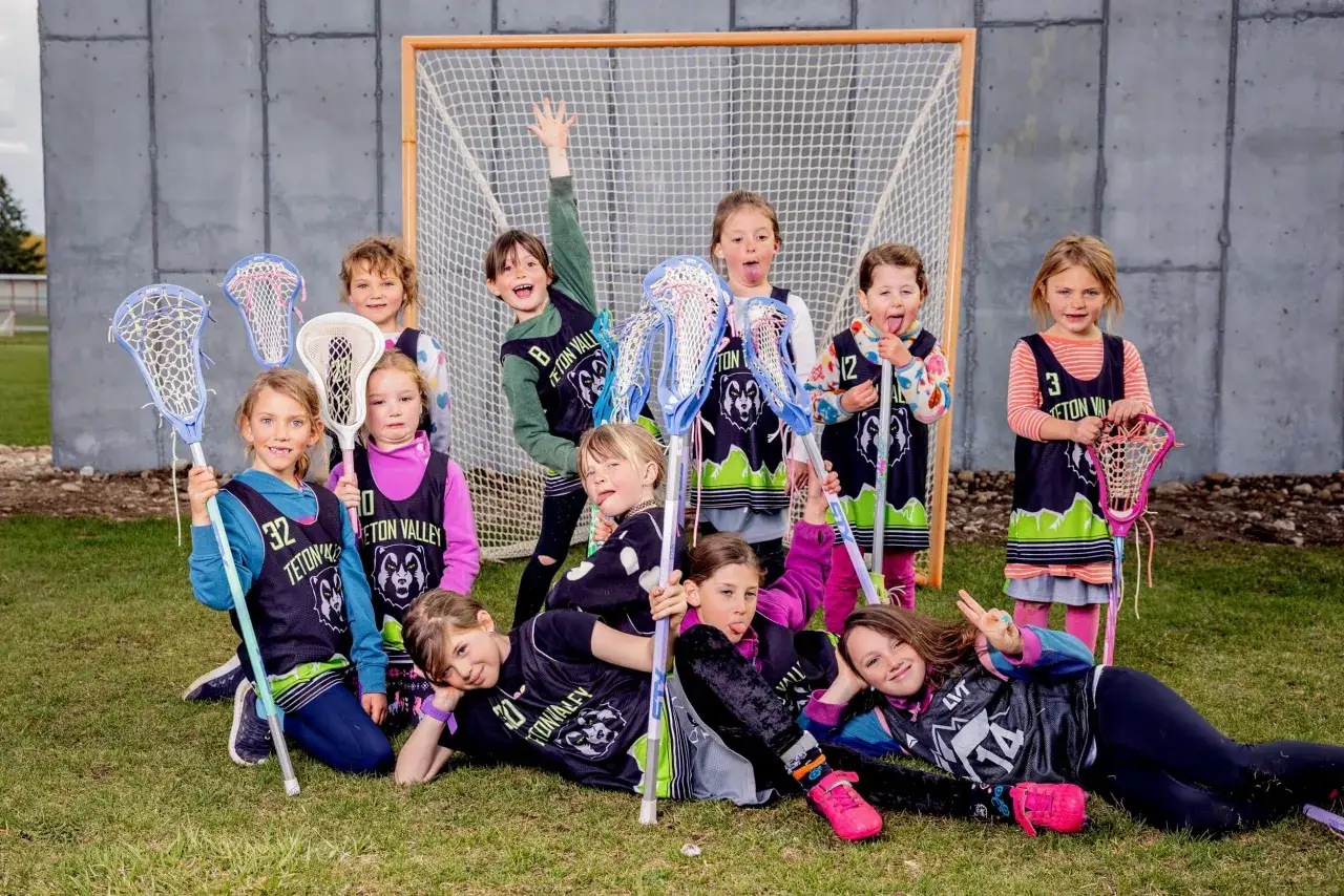 Young lacrosse players pose with sticks, showcasing team spirit. These kids are ready for action, inspiring great lacrosse fundraising ideas!