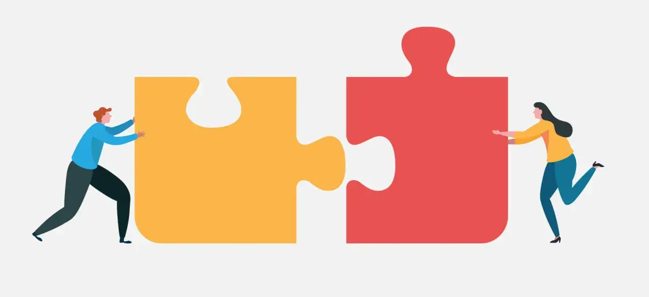 Two people push puzzle pieces together, symbolizing corporate fundraising for nonprofits.