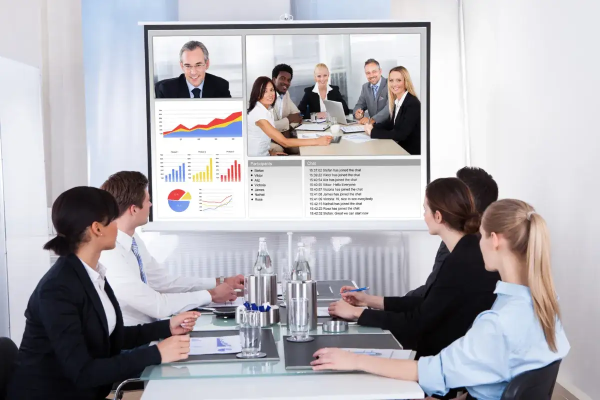 A diverse team uses zoom for non profits, collaborating on charts and chat during a virtual meeting.