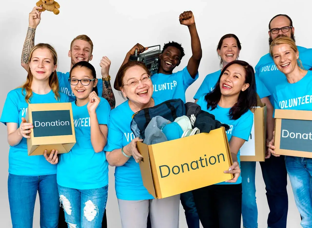 Volunteers in blue shirts hold donation boxes, showing what fundraisers bring in the most money.