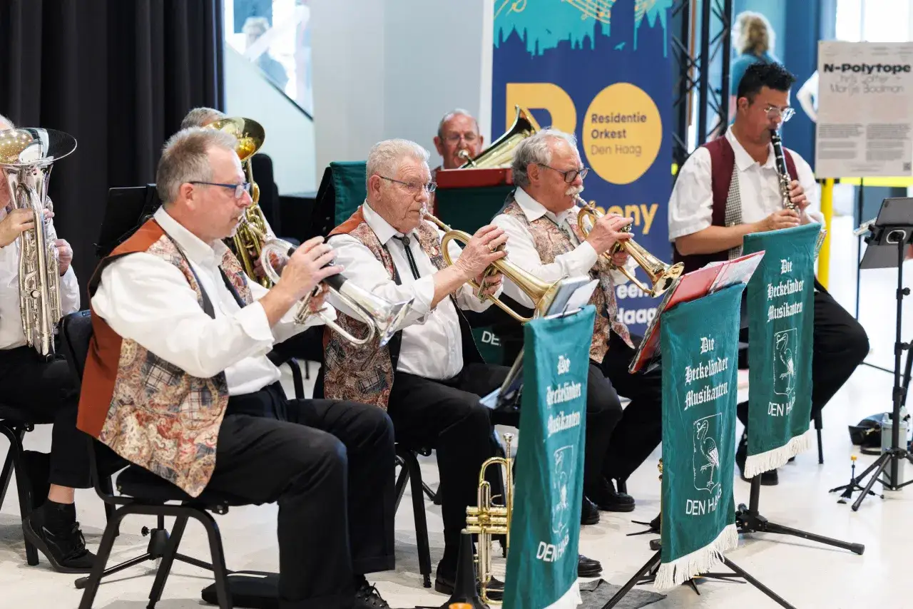 Men in a brass band play instruments, showcasing music volunteer opportunities.