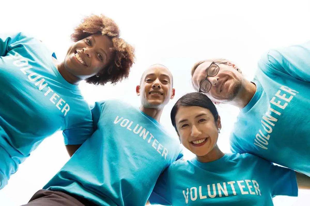 A diverse group of smiling people in bright blue 