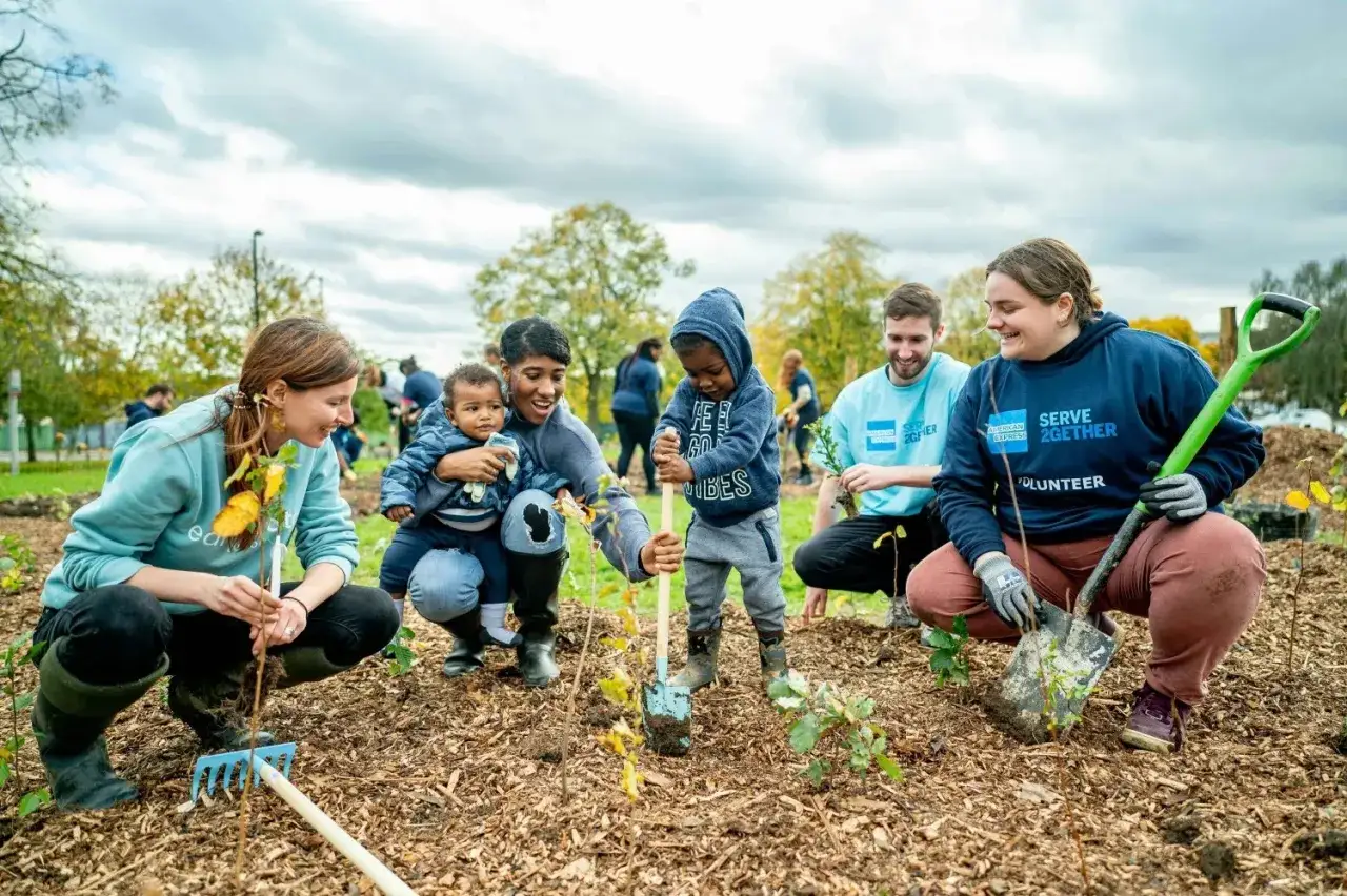 Volunteers of all ages participate in planting trees, showcasing diverse forms of community service.