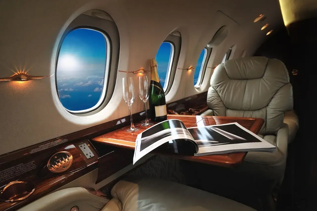 Luxury private jet interior with champagne, glasses, and a magazine, hinting at big ticket raffle items for a dream vacation.